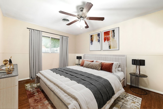 bedroom with ceiling fan, dark wood-style flooring, visible vents, and baseboards