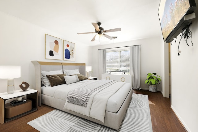 bedroom featuring a ceiling fan, baseboards, and wood finished floors