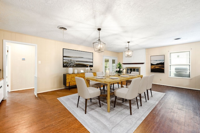 dining area featuring a wealth of natural light, a notable chandelier, and wood finished floors