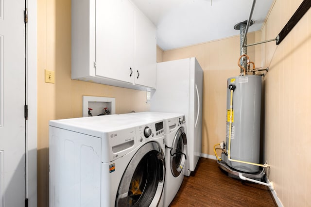 washroom featuring gas water heater, washer and clothes dryer, cabinet space, dark wood-type flooring, and baseboards