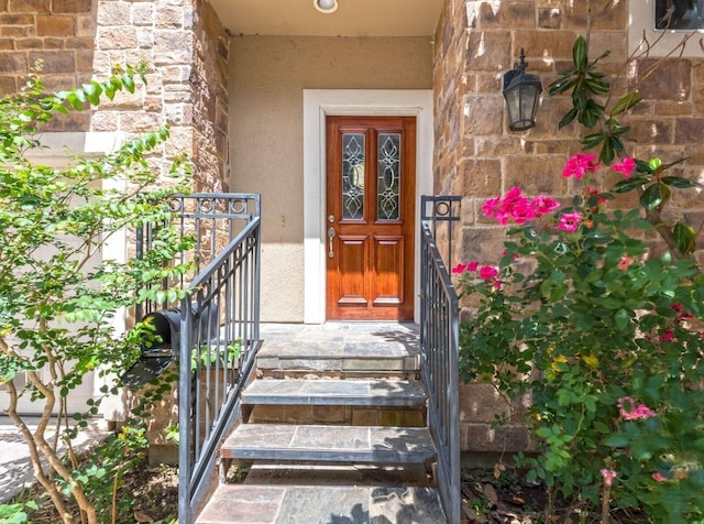 property entrance with stone siding and stucco siding