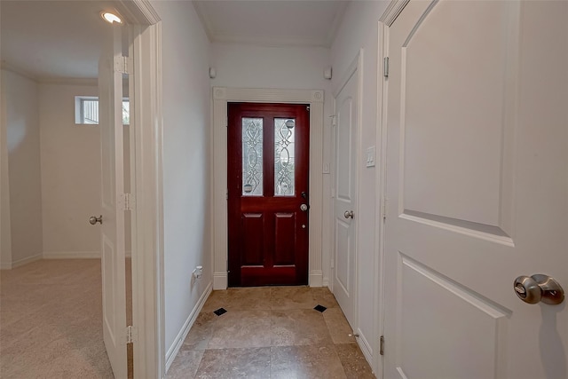 entryway featuring baseboards and crown molding