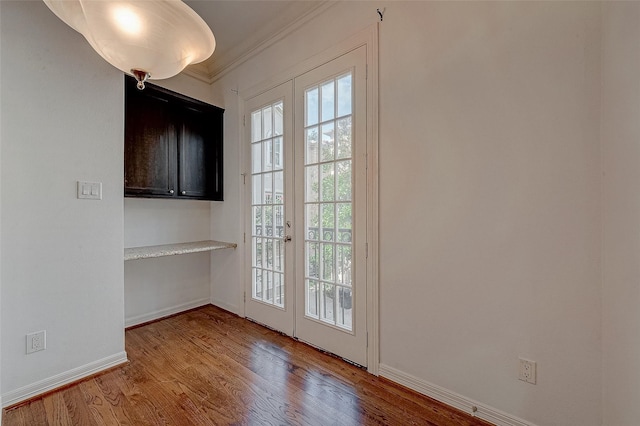 doorway to outside featuring ornamental molding, french doors, wood finished floors, and baseboards