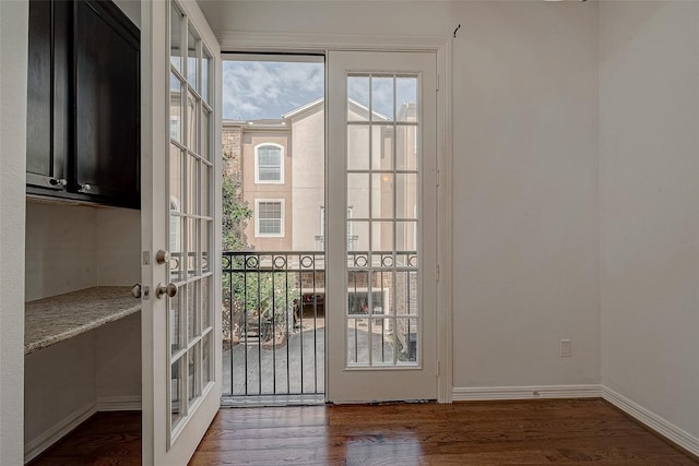 doorway with baseboards and wood finished floors