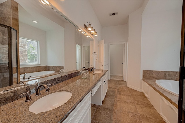 bathroom featuring a stall shower, visible vents, a sink, and a garden tub