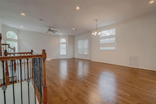 unfurnished room with crown molding, visible vents, and wood finished floors