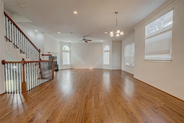 unfurnished living room featuring stairway, ornamental molding, wood finished floors, a tile fireplace, and baseboards