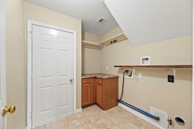 laundry area with gas dryer hookup, laundry area, washer hookup, stone finish floor, and electric dryer hookup