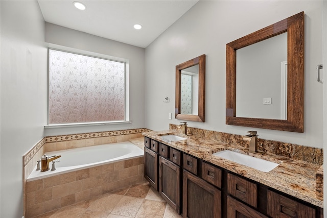 full bath featuring double vanity, a garden tub, a sink, and recessed lighting