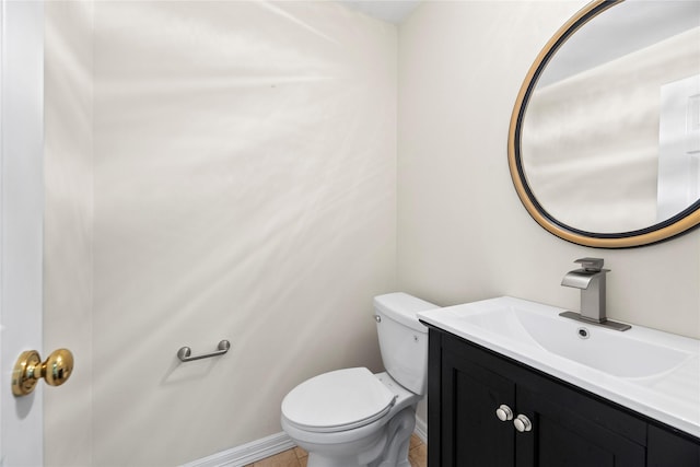 bathroom featuring toilet, baseboards, and vanity