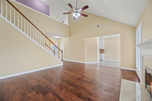 unfurnished living room featuring baseboards, visible vents, hardwood / wood-style floors, and a tile fireplace