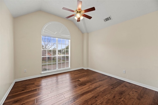 empty room featuring a ceiling fan, vaulted ceiling, visible vents, and dark wood finished floors