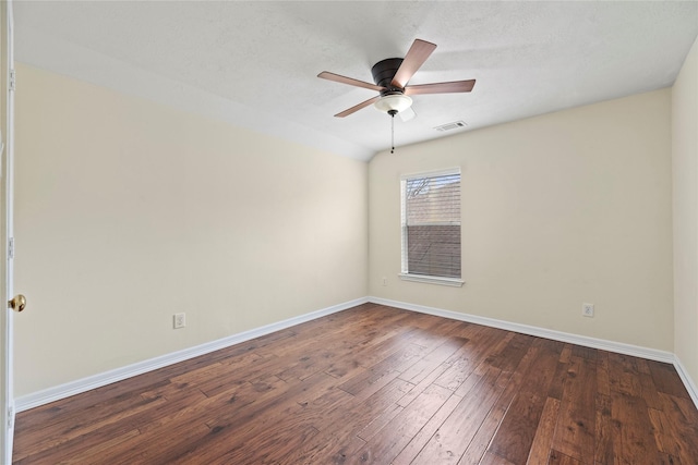 spare room with a ceiling fan, baseboards, visible vents, and dark wood-type flooring