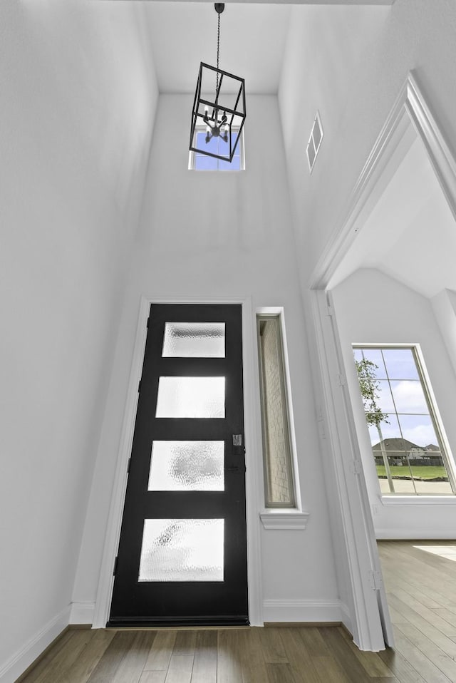 foyer entrance with wood finished floors, visible vents, and baseboards