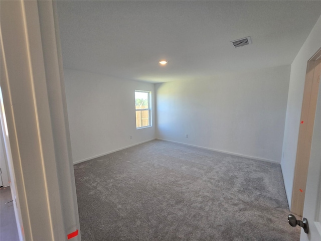 unfurnished room featuring baseboards, visible vents, and carpet flooring