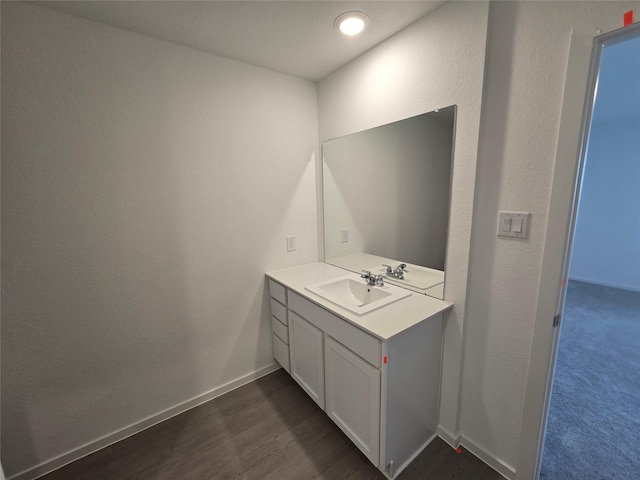 bathroom featuring wood finished floors, vanity, and baseboards