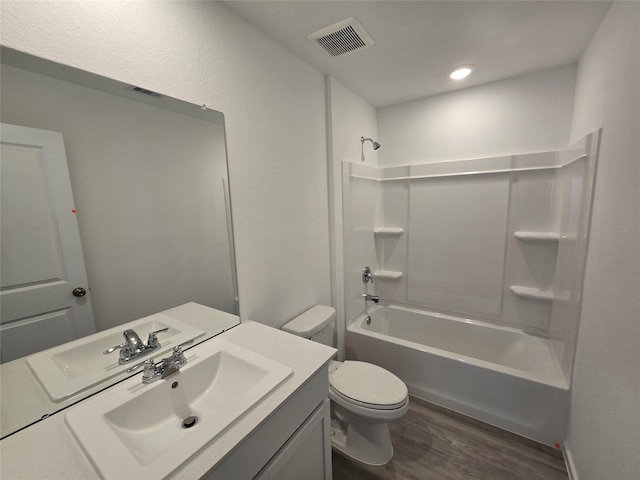 bathroom featuring bathing tub / shower combination, visible vents, toilet, vanity, and wood finished floors