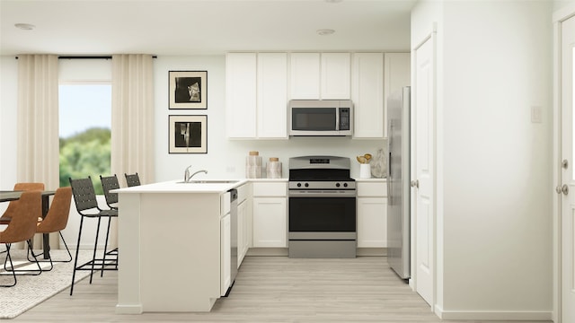 kitchen with light wood-style flooring, a peninsula, stainless steel appliances, white cabinetry, and a sink