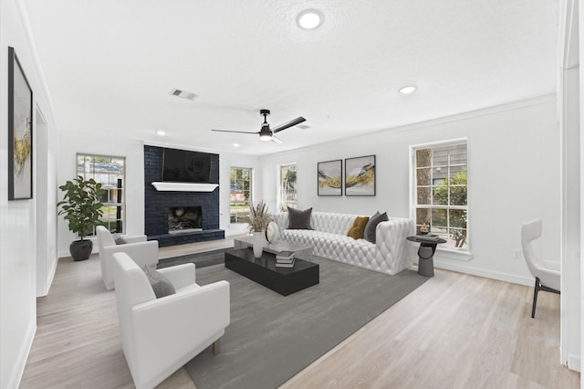 living room featuring recessed lighting, a brick fireplace, wood finished floors, and baseboards