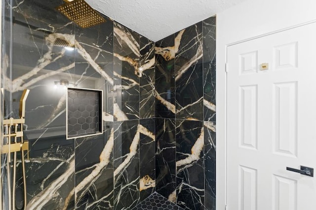 bathroom featuring a textured ceiling and a marble finish shower