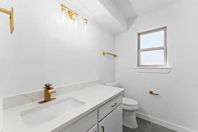 bathroom featuring tile patterned flooring, vanity, toilet, and baseboards