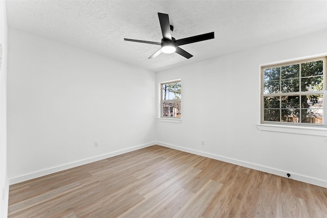 unfurnished room featuring light wood-style floors, a textured ceiling, baseboards, and a ceiling fan