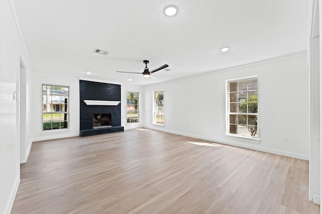 unfurnished living room with light wood-type flooring, a fireplace, and baseboards