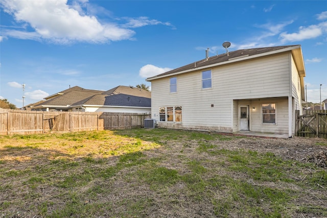 back of property with a fenced backyard and central air condition unit