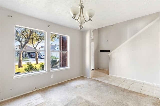 carpeted empty room with a textured ceiling, stairway, tile patterned flooring, and a chandelier