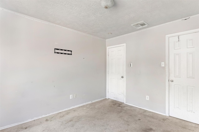 unfurnished room featuring baseboards, visible vents, a textured ceiling, and carpet flooring