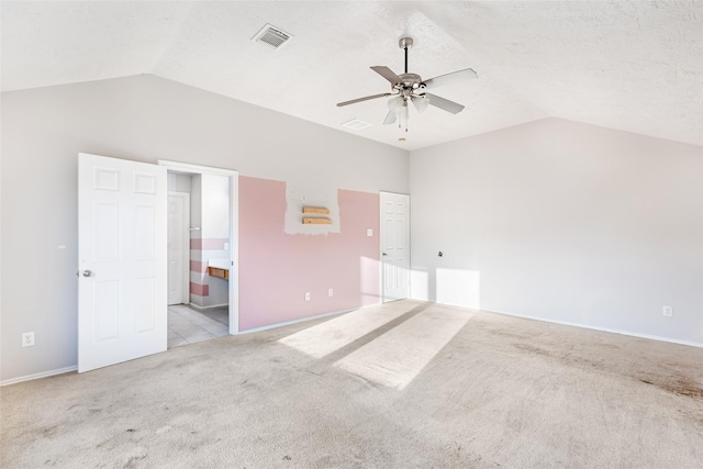 unfurnished bedroom with carpet floors, lofted ceiling, visible vents, and a textured ceiling