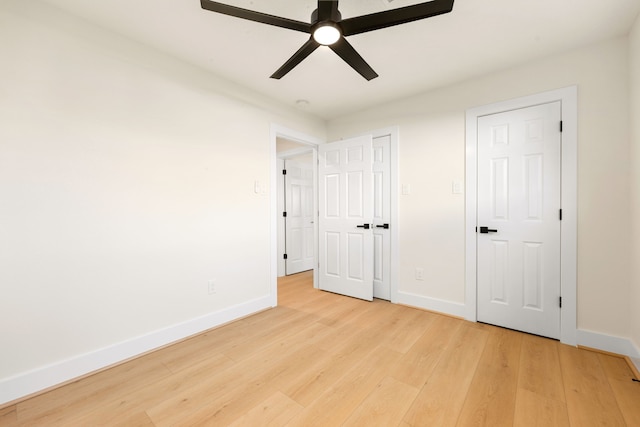 unfurnished bedroom with baseboards, a ceiling fan, and light wood-style floors