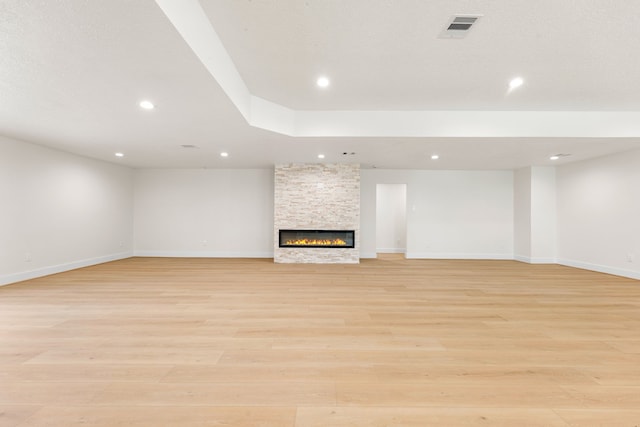 unfurnished living room featuring a fireplace, recessed lighting, visible vents, light wood-style floors, and baseboards