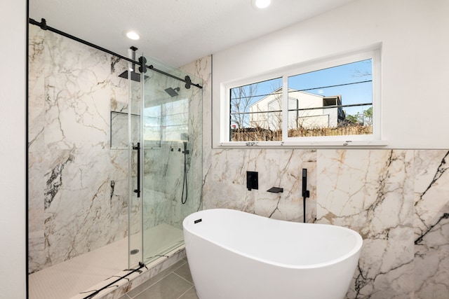 full bathroom with a soaking tub, a marble finish shower, tile walls, and recessed lighting