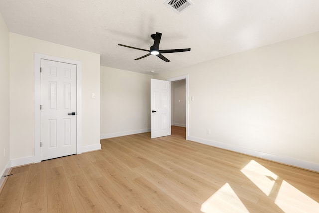 unfurnished bedroom featuring light wood finished floors, a ceiling fan, visible vents, and baseboards