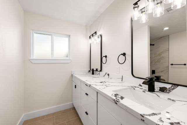 bathroom featuring tile patterned flooring, a sink, baseboards, and double vanity