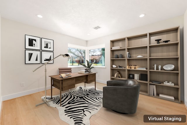 office area with light wood finished floors, recessed lighting, visible vents, and baseboards