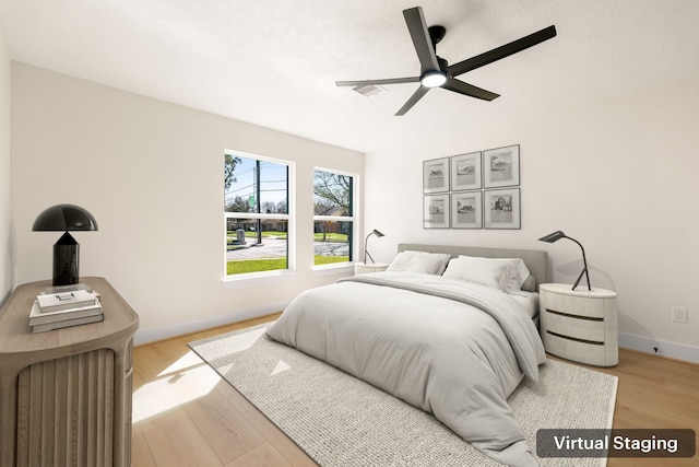 bedroom featuring baseboards, ceiling fan, and light wood finished floors