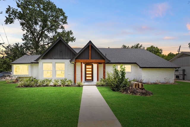 8018 Highmeadow Dr, Houston, TX 77063 - view of front of house with brick siding, a yard, a shingled roof, and board and batten siding