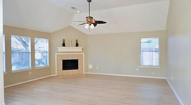 unfurnished living room with light wood finished floors, baseboards, a ceiling fan, a tiled fireplace, and vaulted ceiling