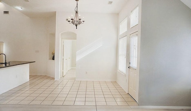 unfurnished dining area featuring visible vents, plenty of natural light, an inviting chandelier, and light tile patterned floors