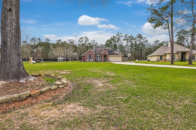 view of yard with concrete driveway and an attached garage