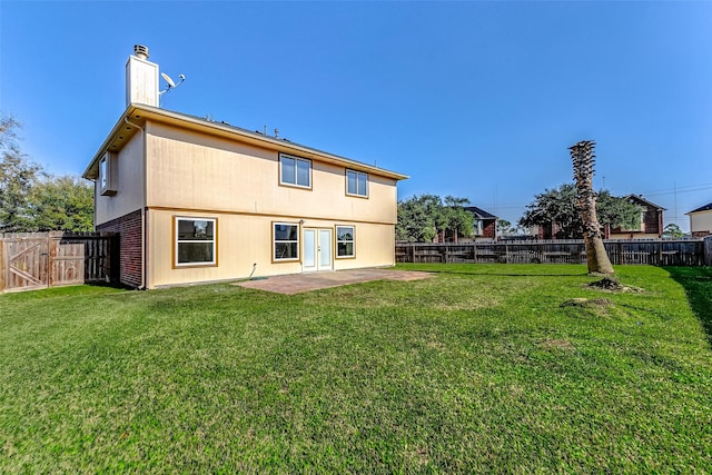 rear view of house with a patio area, a fenced backyard, a chimney, and a yard