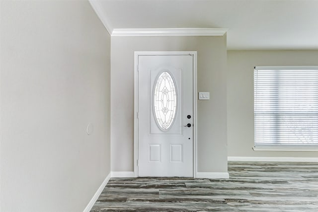 foyer featuring baseboards, a healthy amount of sunlight, wood finished floors, and crown molding