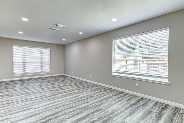 empty room with baseboards, visible vents, and recessed lighting