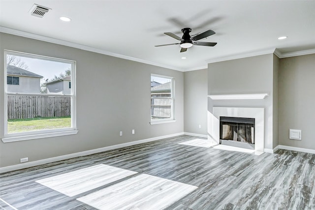 unfurnished living room with baseboards, visible vents, and crown molding