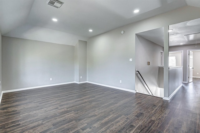 unfurnished room featuring attic access, visible vents, dark wood finished floors, and baseboards