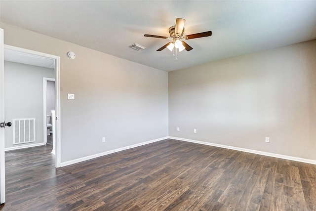 unfurnished room featuring dark wood-style floors, baseboards, visible vents, and a ceiling fan