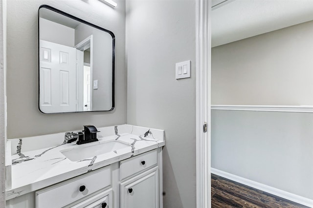 bathroom with wood finished floors, vanity, and baseboards