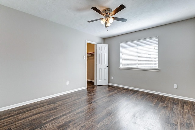 spare room featuring ceiling fan, a textured ceiling, dark wood finished floors, and baseboards